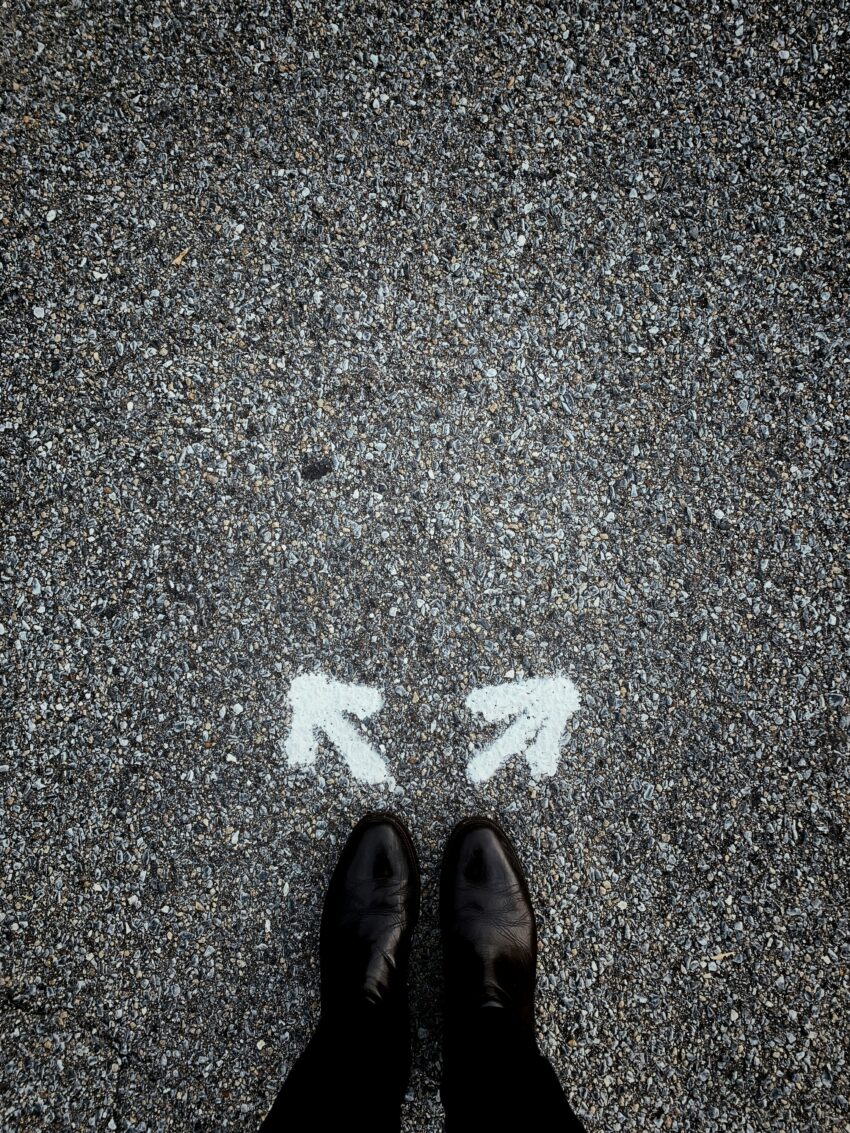 a pair of shoes standing in front of two arrows, not knowing which one to choose